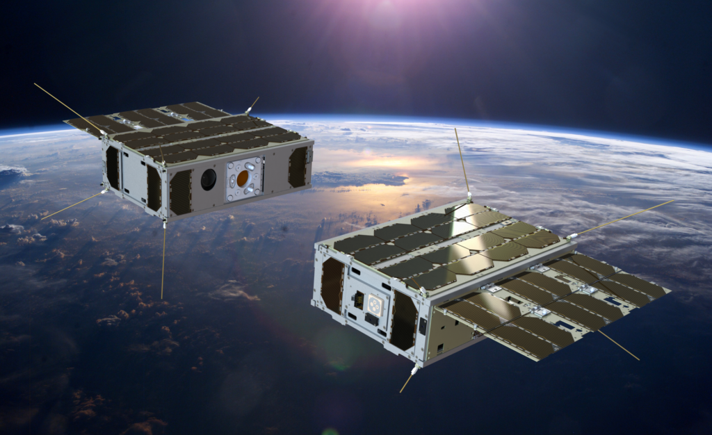 Cubesat duplo da missão RACE (Rendezvous Autonomous CubeSats Experiment), da Agência Espacial Europeia (ESA). Os cubesats estão no espaço, com painéis solares abertos e ao fundo há a representação de um planeta. Imagem da ESA